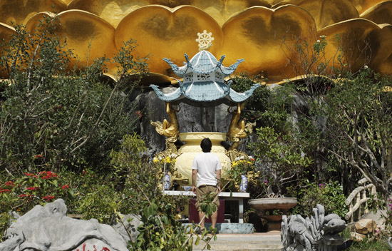 Andrei Verner standing beneath the Big Golden Buddha statue in Da Lat, Vietnam